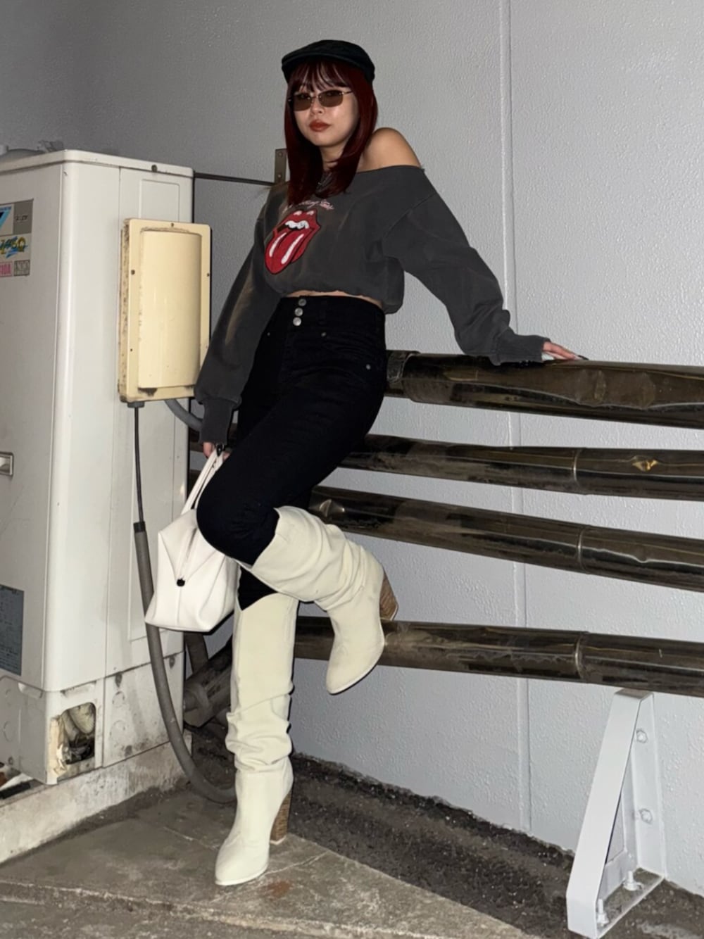 ホワイト系のボストンバッグ、ホワイト系のブーツ、ブラック系のスウェットを着用したレディースの冬コーディネートの1枚目の写真