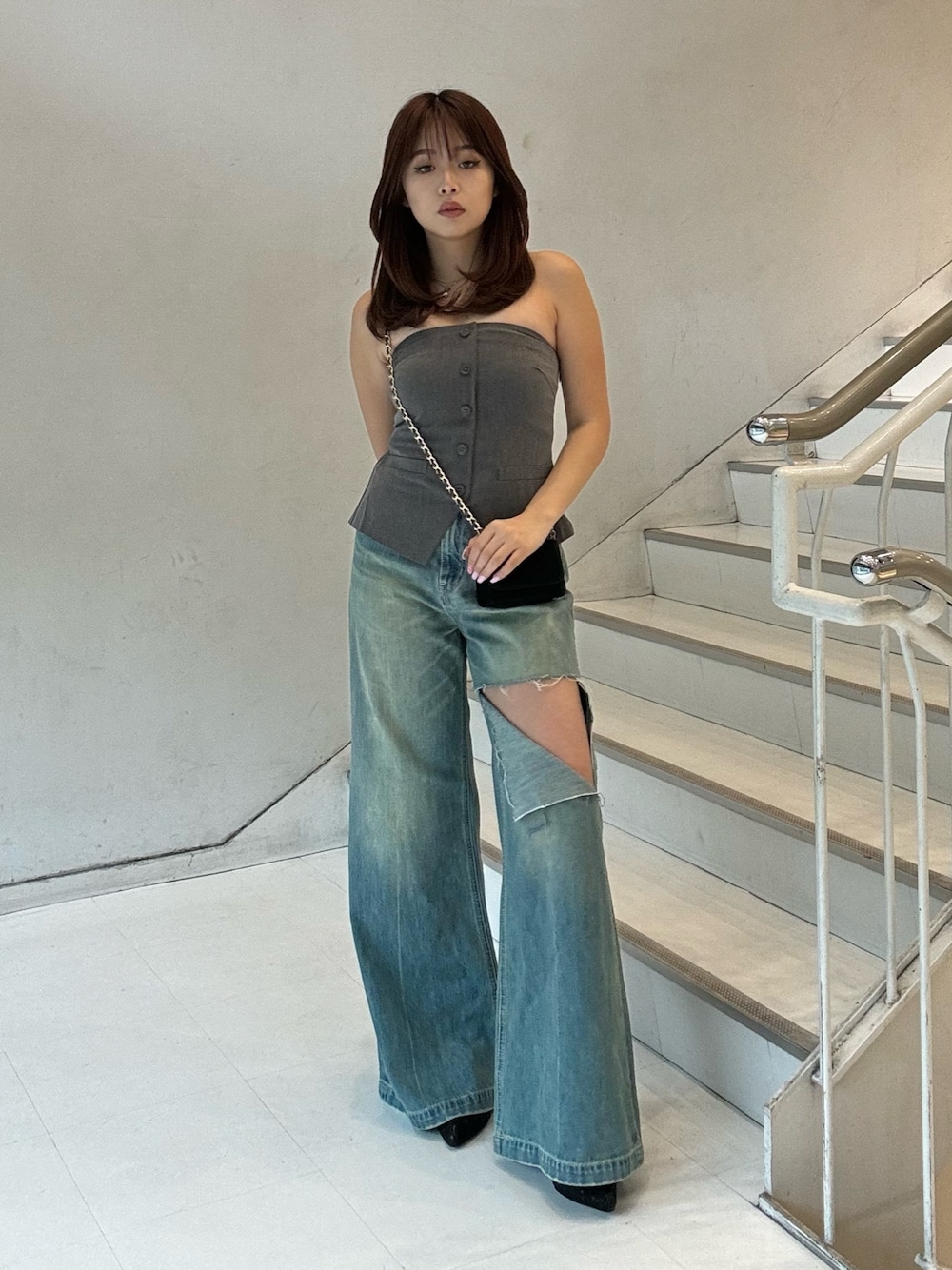 グレー系のキャミソール、ブラック系のブーツ、ブラック系のショルダーバッグを着用したレディースの春コーディネートの1枚目の写真