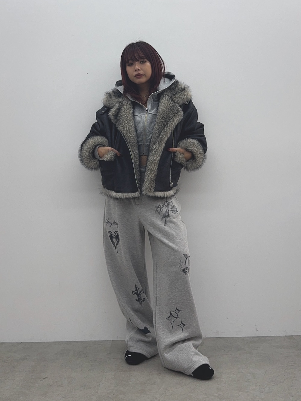 グレー系のパーカー、ブラック系のブルゾン、グレー系のスウェットパンツを着用したレディースの秋コーディネートの1枚目の写真