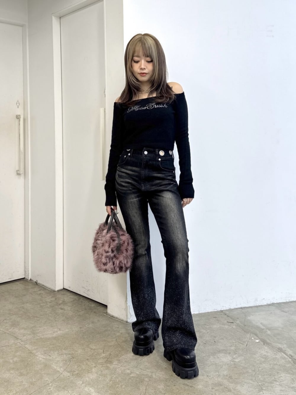 ブラック系のニット/セーター、ブラック系のデニムパンツ、ピンク系のボストンバッグを着用したレディースの夏コーディネートの1枚目の写真