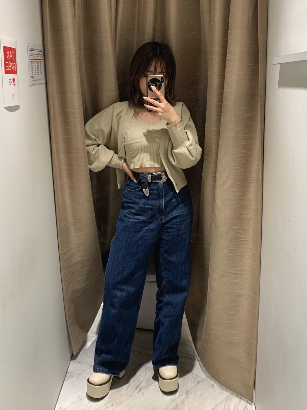 ブルー系のデニムパンツ、ホワイト系のカーディガン/ボレロ、ホワイト系のブーツを着用したレディースの冬コーディネートの1枚目の写真