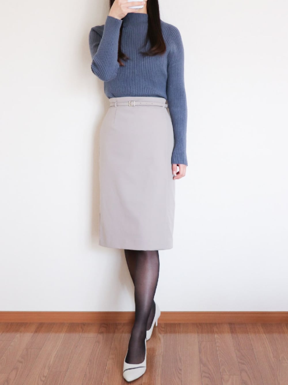 ブルー系のニット/セーター、ベージュ系のスカート、ホワイト系のパンプスを着用したレディースの冬コーディネートの1枚目の写真