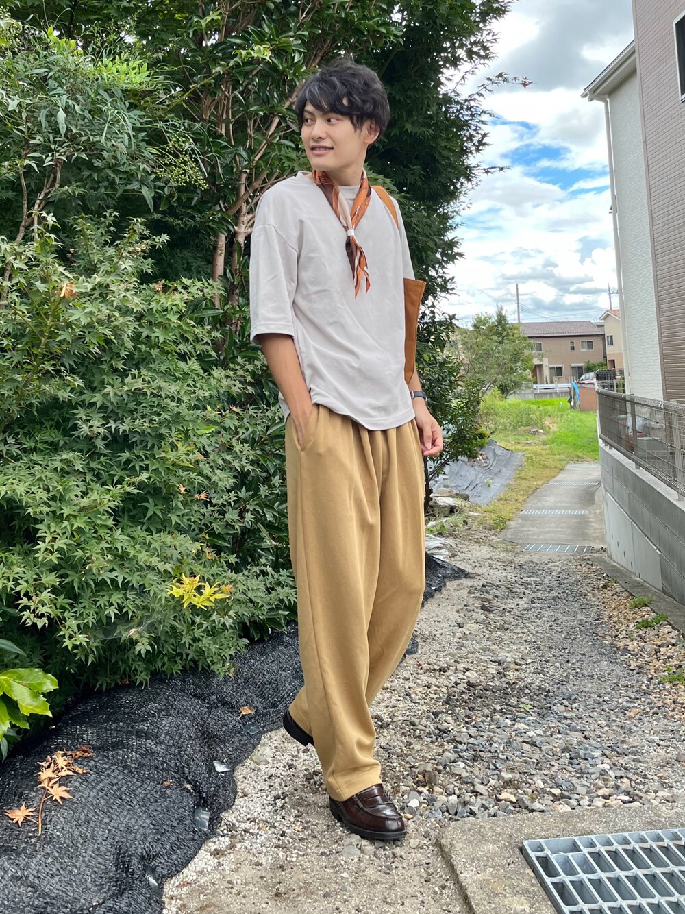 グレー系のトップス、ベージュ系のスウェットパンツ、ブラウン系のローファーを着用したメンズの夏コーディネートの1枚目の写真