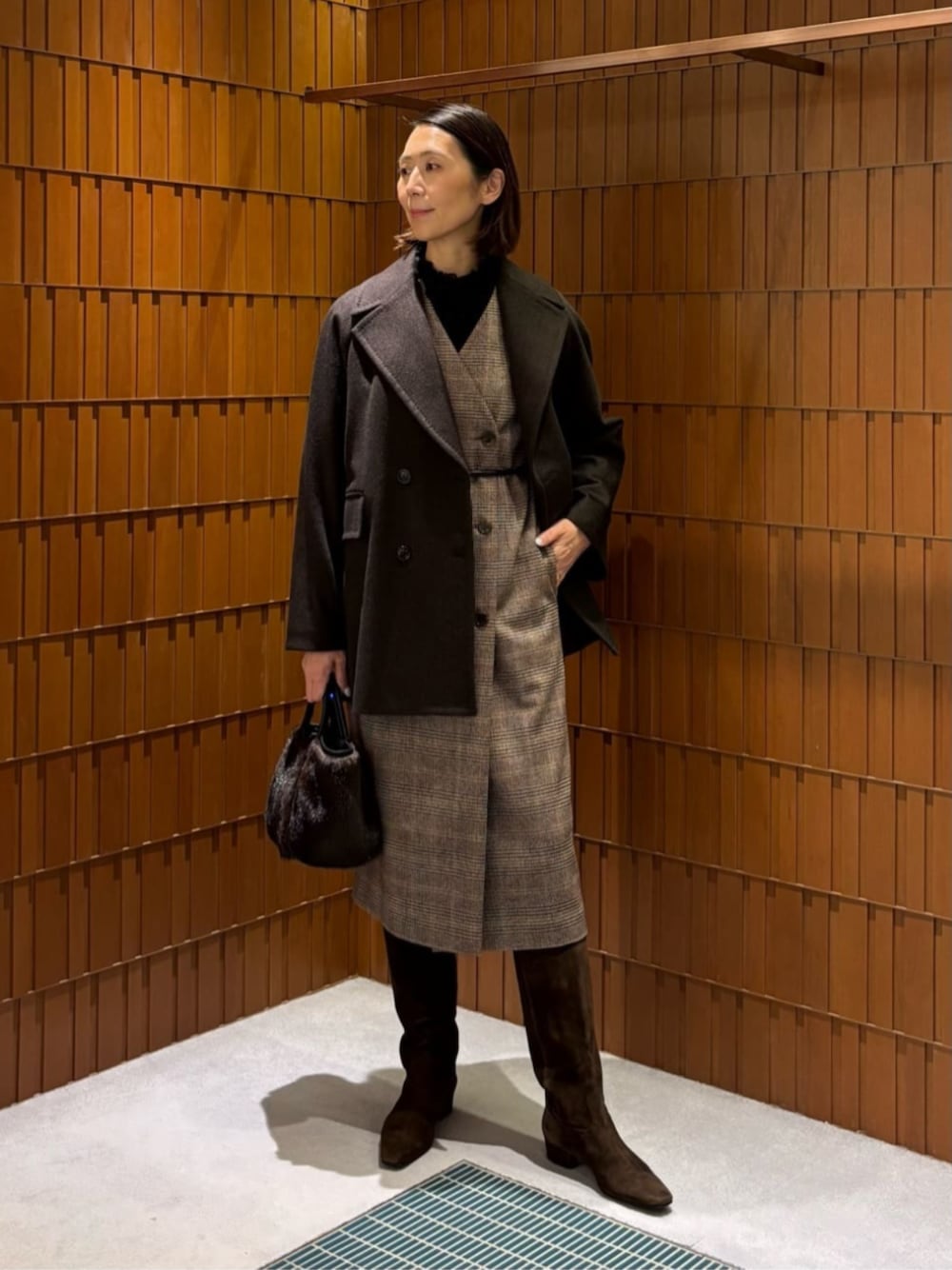 ブラウン系のブーツ、ブラウン系のピーコート、ブラウン系のワンピースを着用したレディースの秋コーディネートの1枚目の写真