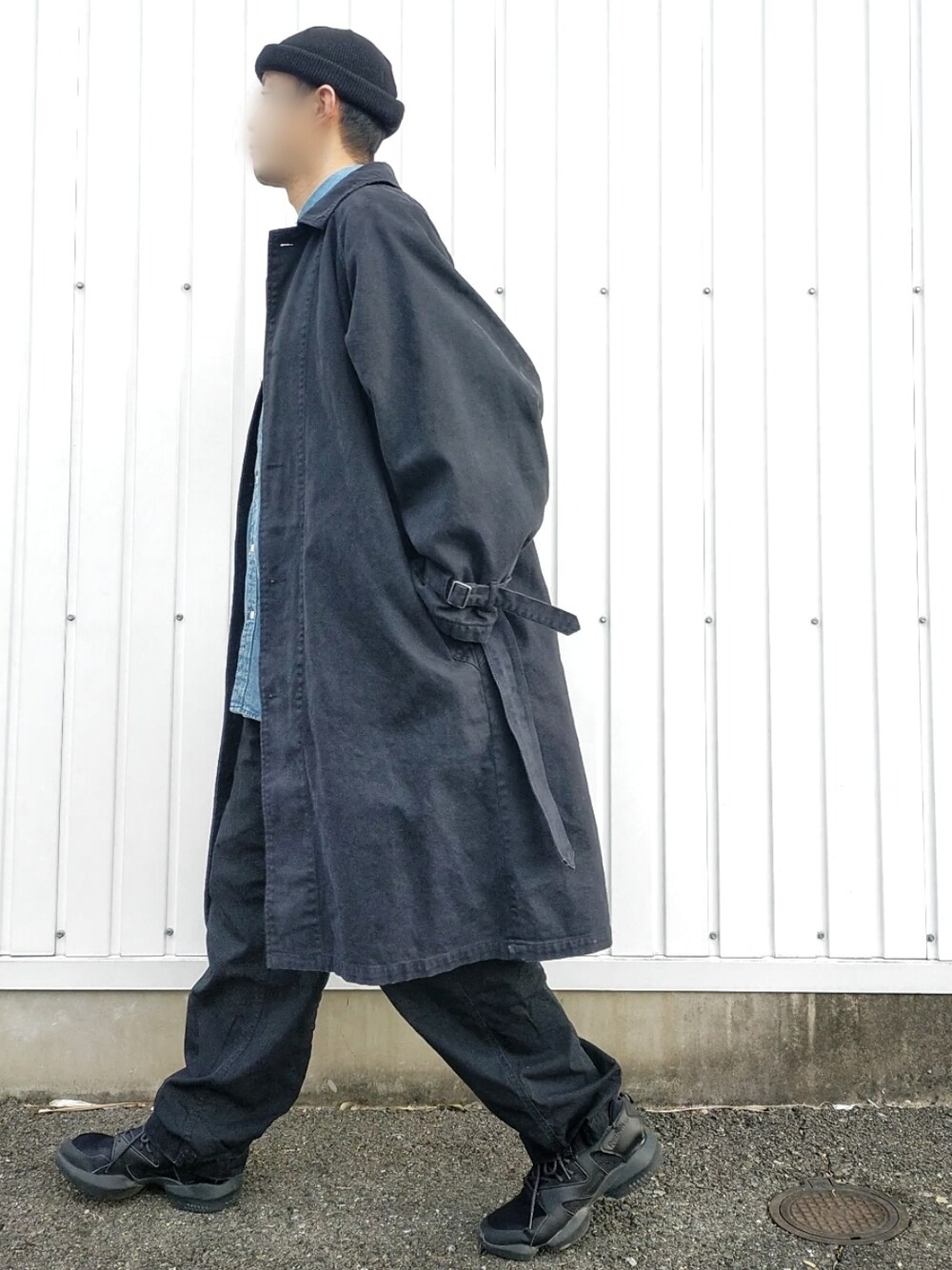 ブラック系のステンカラーコート、ブルー系のシャツ/ブラウス、ブラック系のスニーカーを着用したメンズの春コーディネートの3枚目の写真