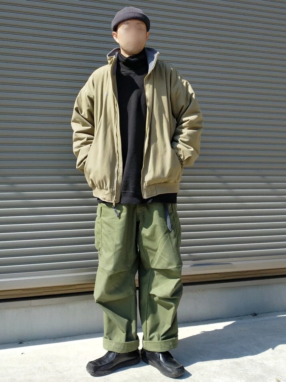 グリーン系のカーゴパンツ、ブラック系のその他シューズ、ベージュ系のブルゾンを着用したメンズの冬コーディネートの2枚目の写真