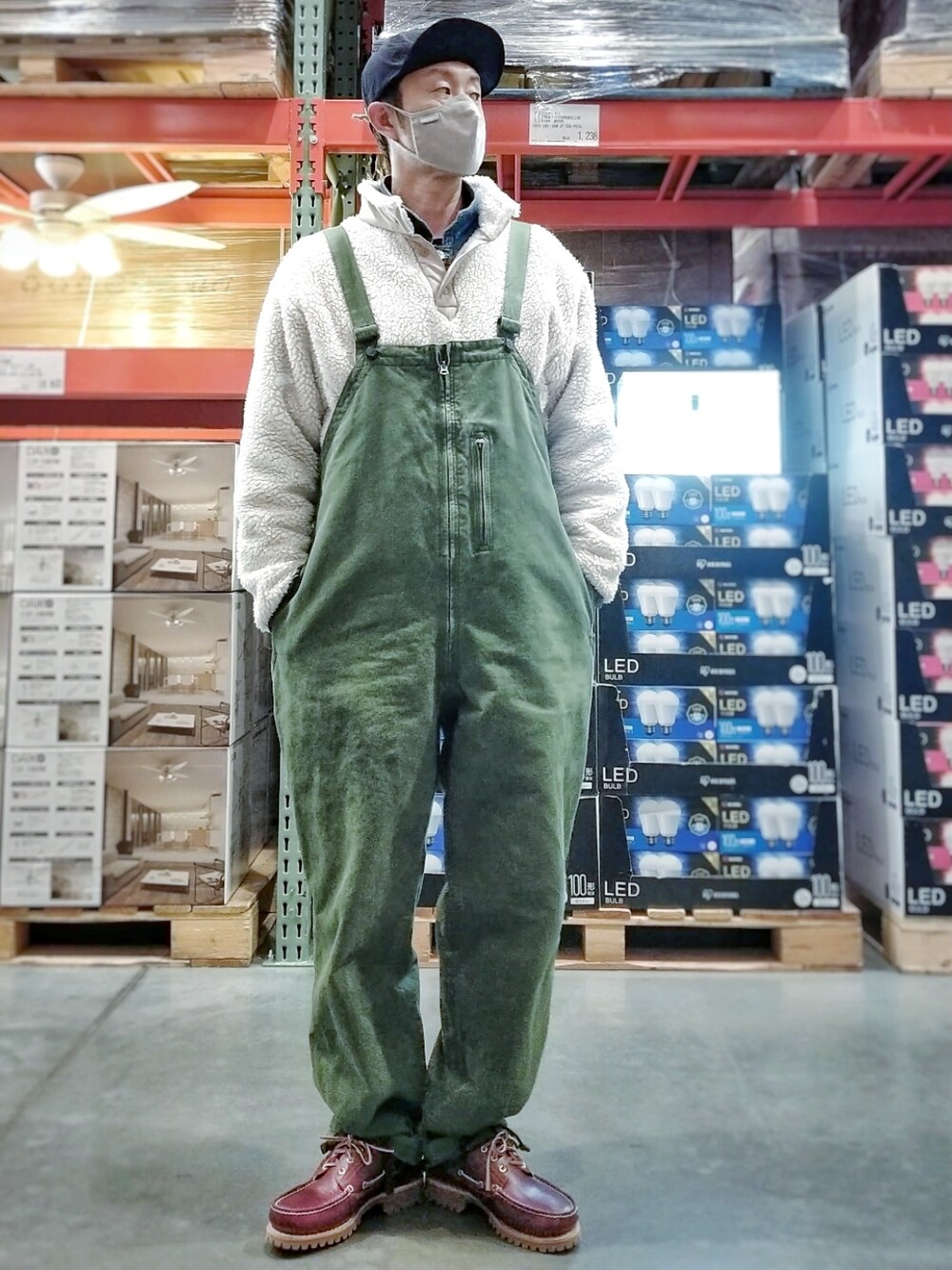 レッド系のスニーカー、グリーン系のサロペット/オーバーオール、ブラック系のトップスを着用したメンズの冬コーディネートの2枚目の写真