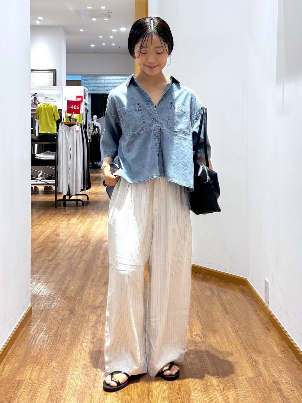 ブラック系のボストンバッグ、ベージュ系のその他パンツ、ブルー系のシャツ/ブラウスを着用したレディースの夏コーディネートの1枚目の写真