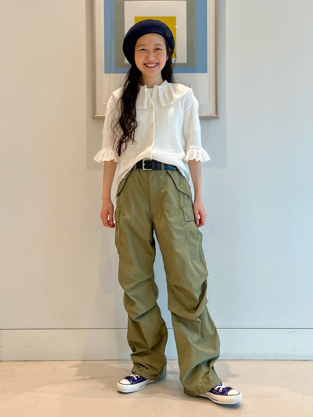 ホワイト系のTシャツ/カットソー、パープル系のスニーカー、ブルー系のハンチング/ベレー帽を着用したレディースの春コーディネートの1枚目の写真