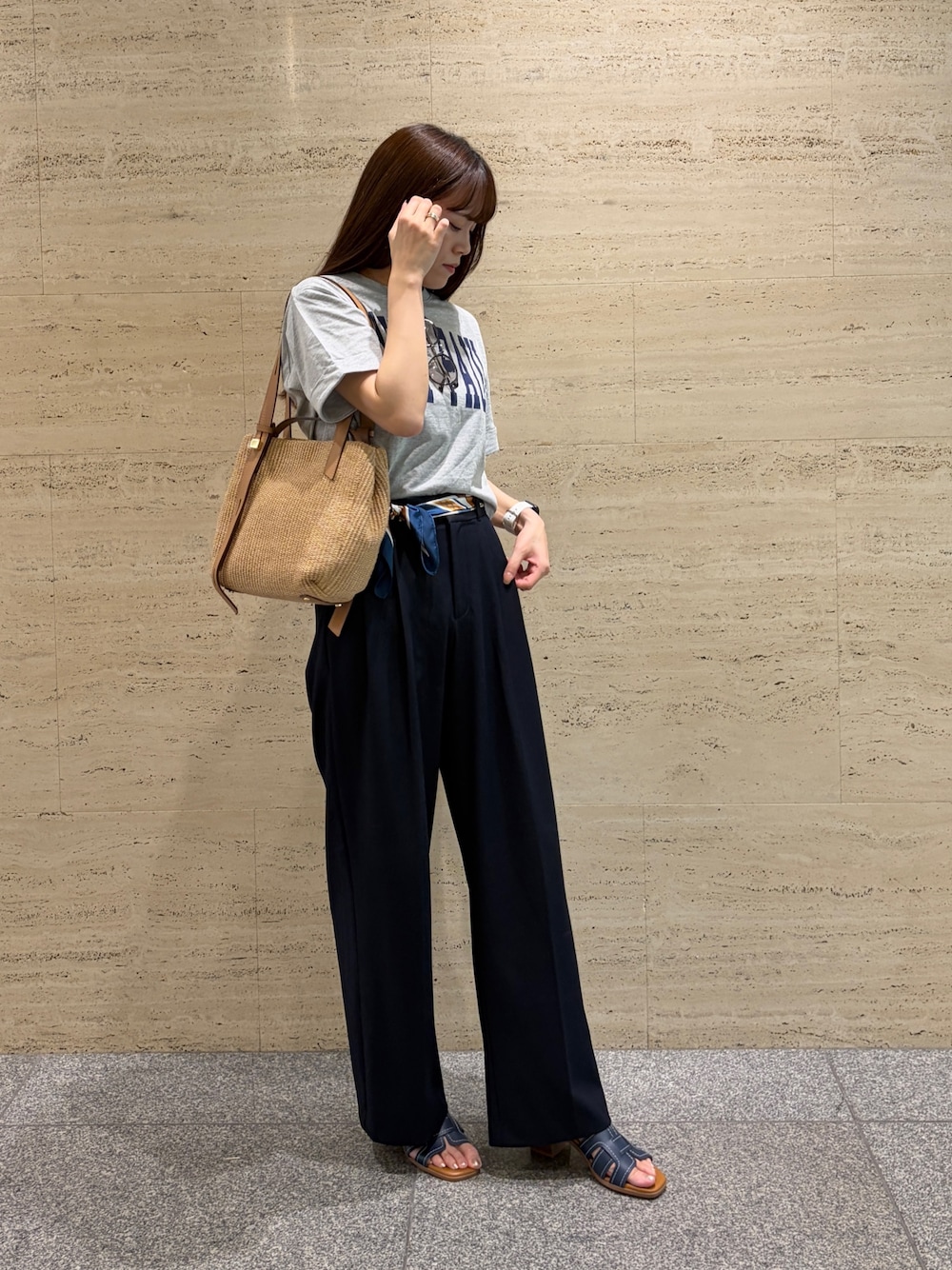 ブルー系のスラックス、グレー系のTシャツ/カットソー、ブラウン系のトートバッグを着用したレディースの夏コーディネートの1枚目の写真