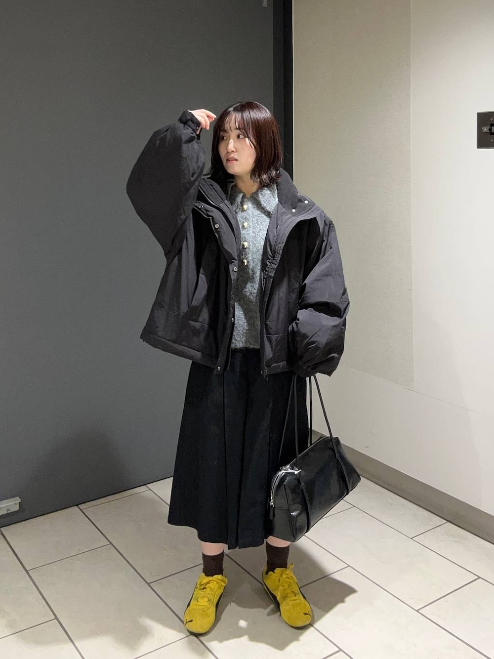 ブラック系のその他アウター、ブラック系のチノパンツ、ブラック系のボストンバッグを着用したレディースの秋コーディネートの1枚目の写真