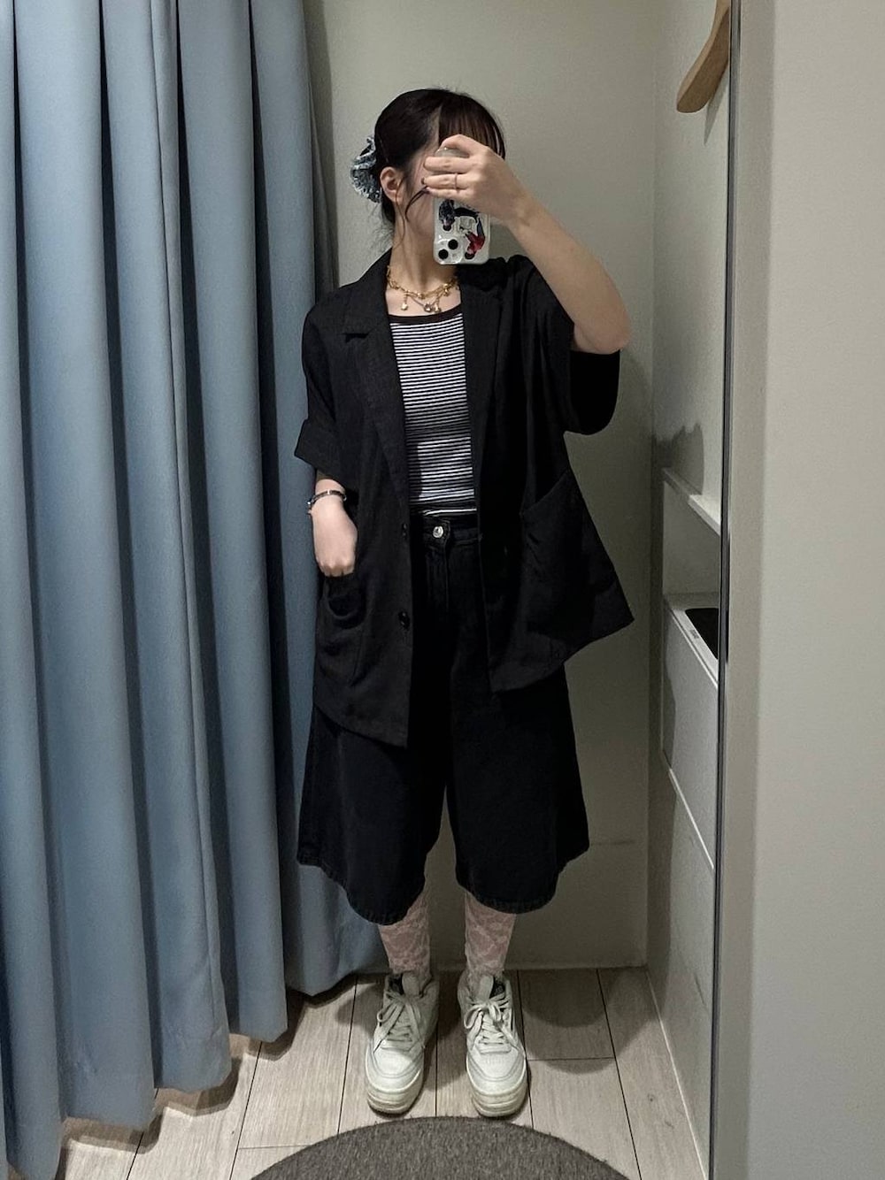 ブルー系のタンクトップ、ブラック系のデニムパンツ、グレー系のテーラードジャケットを着用したレディースの夏コーディネートの1枚目の写真