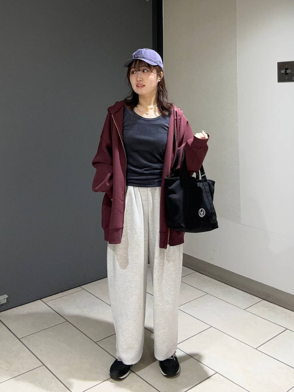 グレー系のスウェットパンツ、ブラック系のショルダーバッグ、レッド系のパーカーを着用したレディースの秋コーディネートの1枚目の写真