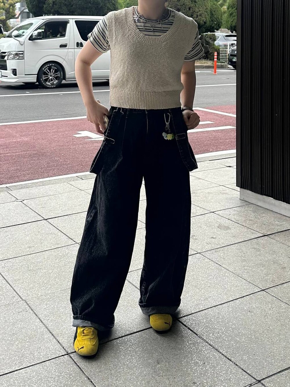 ホワイト系のTシャツ/カットソー、ブラック系のデニムパンツ、ベージュ系のニット/セーターを着用したレディースの春コーディネートの1枚目の写真