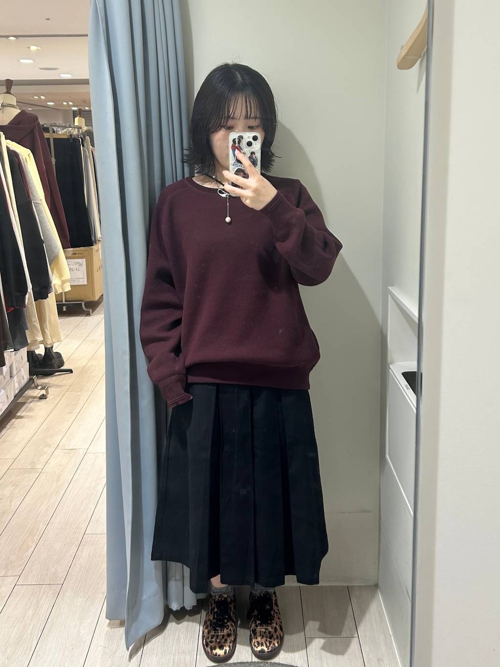 ブラック系のその他アウター、その他のスニーカー、レッド系のニット/セーターを着用したレディースの秋コーディネートの1枚目の写真