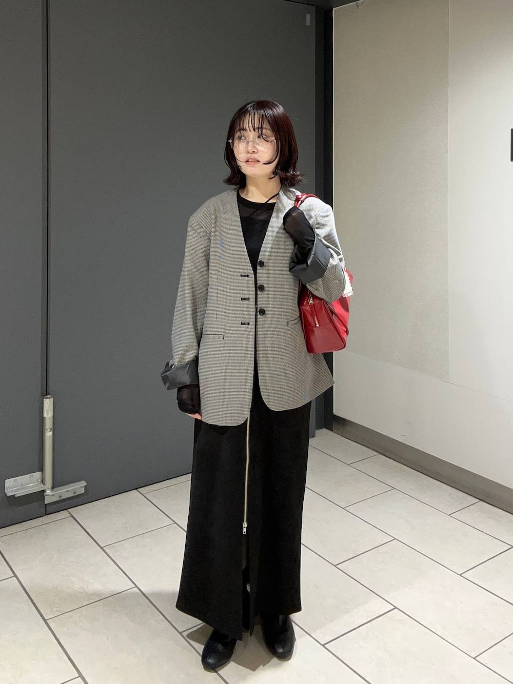 その他のテーラードジャケット、ブラック系のスカート、レッド系のボストンバッグを着用したレディースの秋コーディネートの1枚目の写真