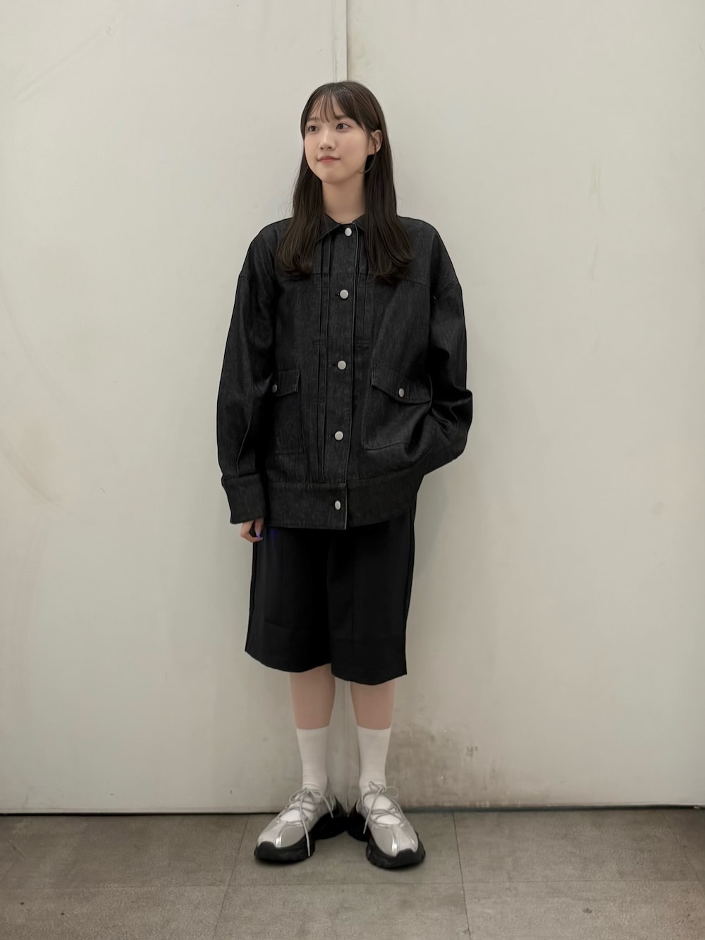 ブラック系のデニムジャケット、ブラック系のその他パンツ、グレー系のスニーカーを着用したレディースの秋コーディネートの1枚目の写真