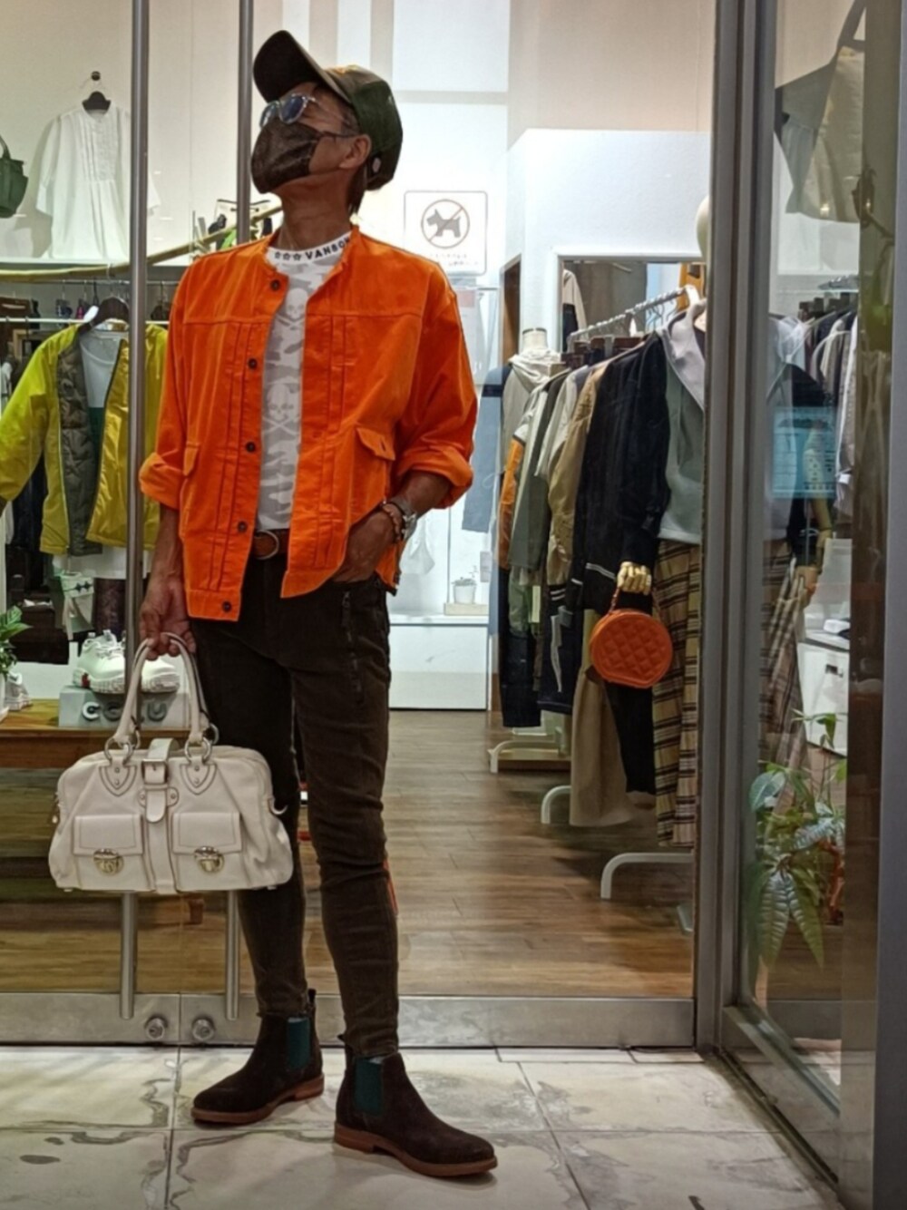 オレンジ系のシャツ/ブラウス、グリーン系のデニムパンツ、ホワイト系のハンドバッグを着用したメンズの秋コーディネートの1枚目の写真