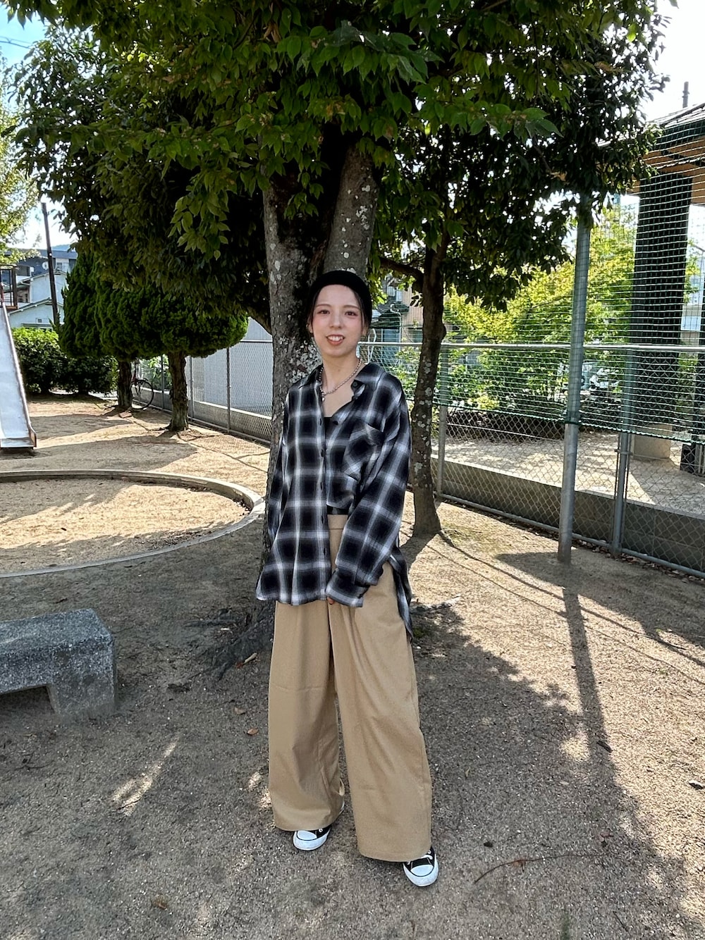 ブラック系のスニーカー、ブラック系のシャツ/ブラウス、ブラック系のスラックスを着用したレディースの秋コーディネートの1枚目の写真