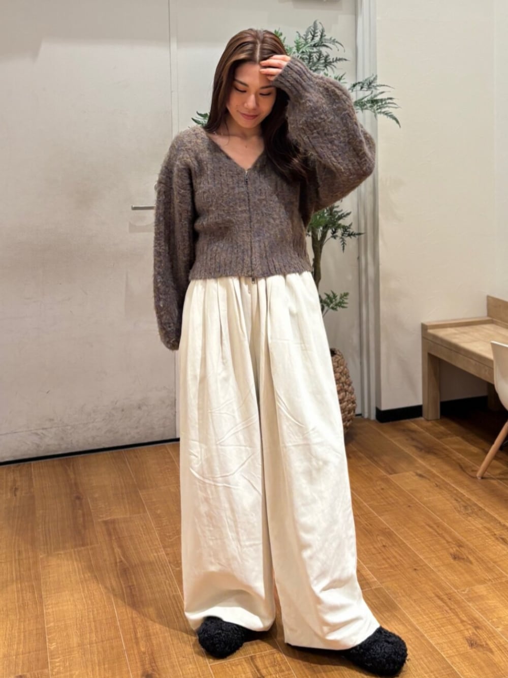 ブラウン系のカーディガン/ボレロ、ホワイト系のその他パンツ、ブラック系のスリッポンを着用したレディースの冬コーディネートの1枚目の写真