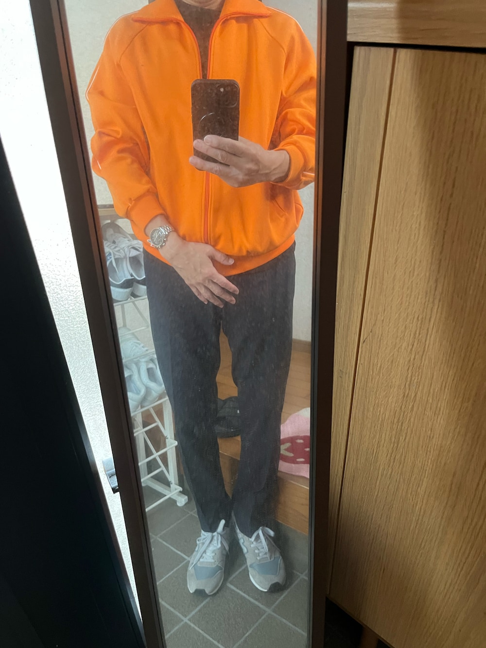 ブラック系のTシャツ/カットソー、オレンジ系のその他アウター、その他のスラックスを着用したメンズの秋コーディネートの1枚目の写真