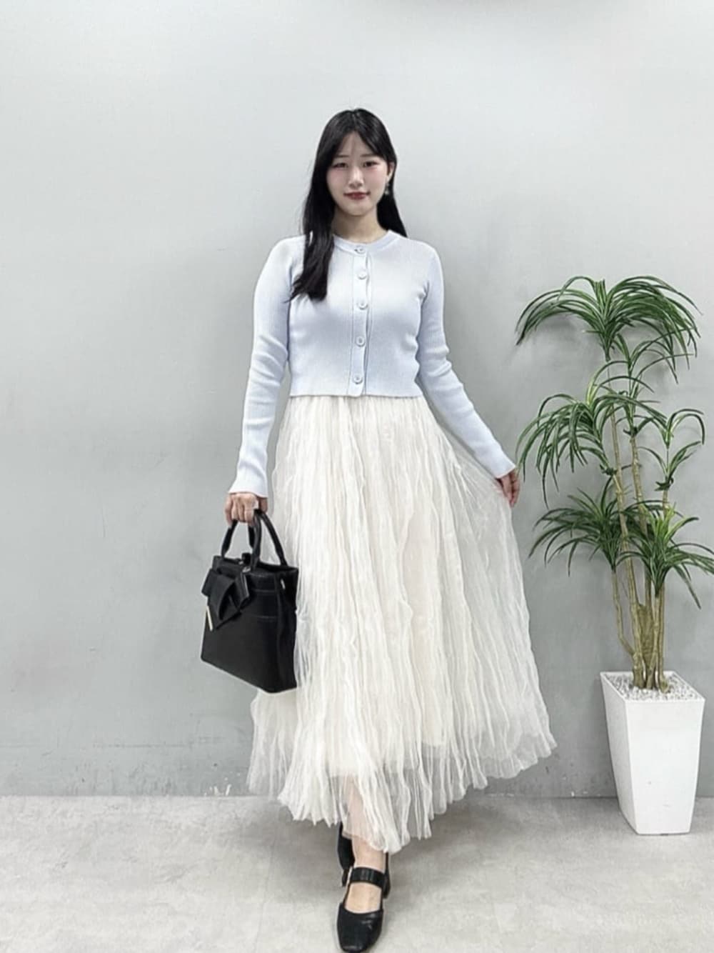 ホワイト系のスカート、ブルー系のカーディガン/ボレロを着用したレディースの春コーディネートの1枚目の写真