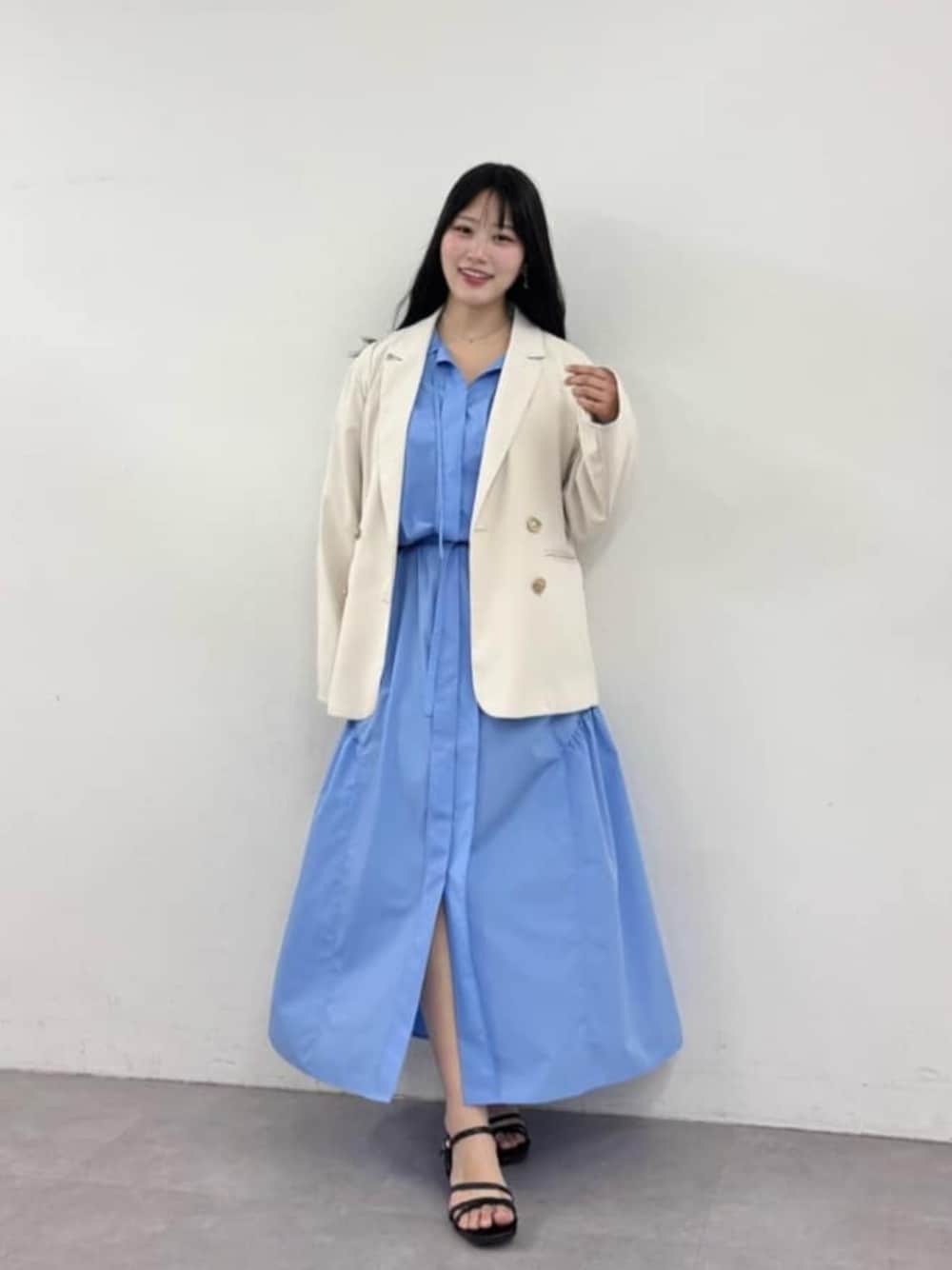 ホワイト系のテーラードジャケット、ブルー系のシャツワンピースを着用したレディースの春コーディネートの1枚目の写真