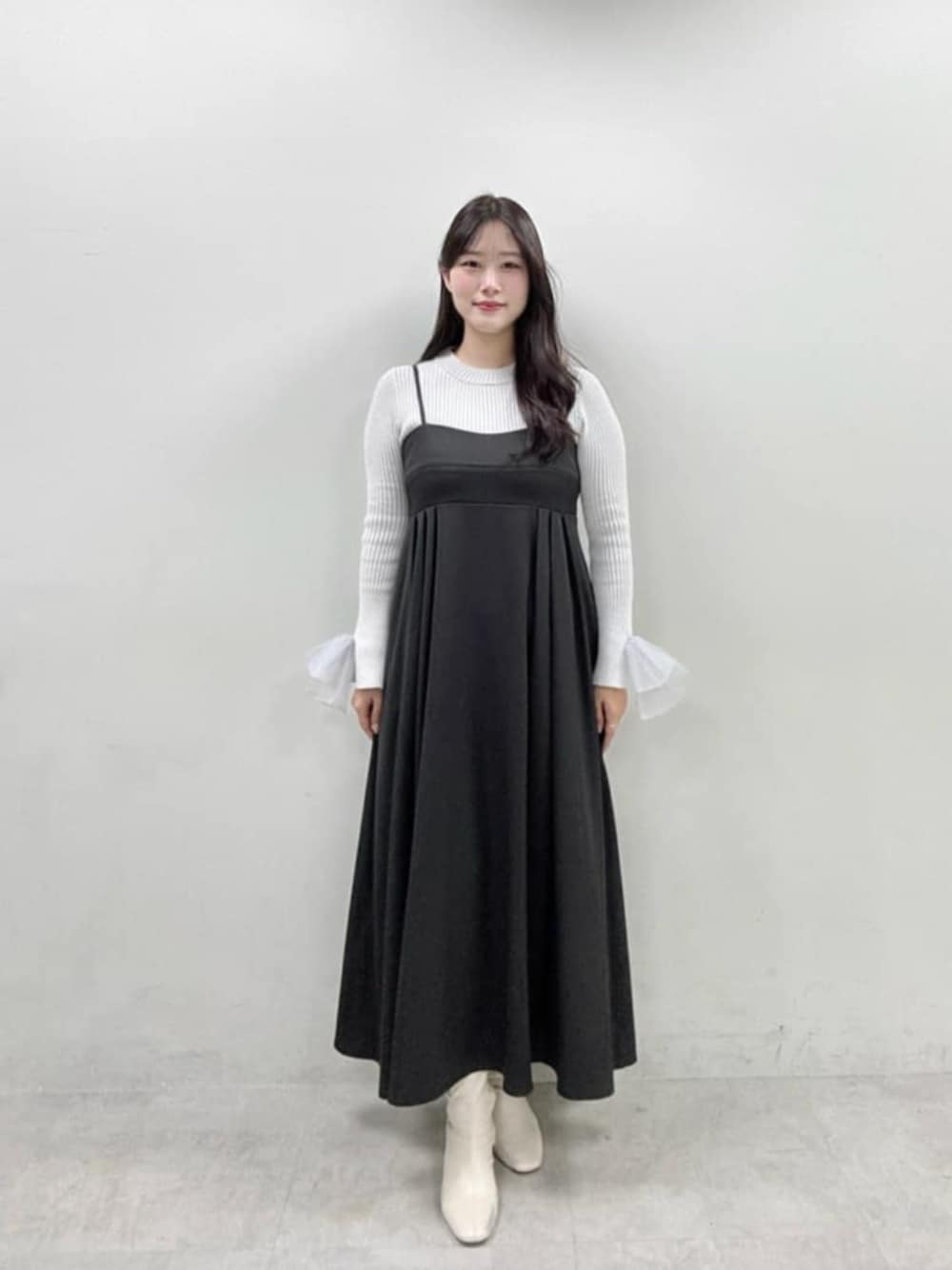 グレー系のニット/セーター、ブラック系のワンピースを着用したレディースの冬コーディネートの1枚目の写真