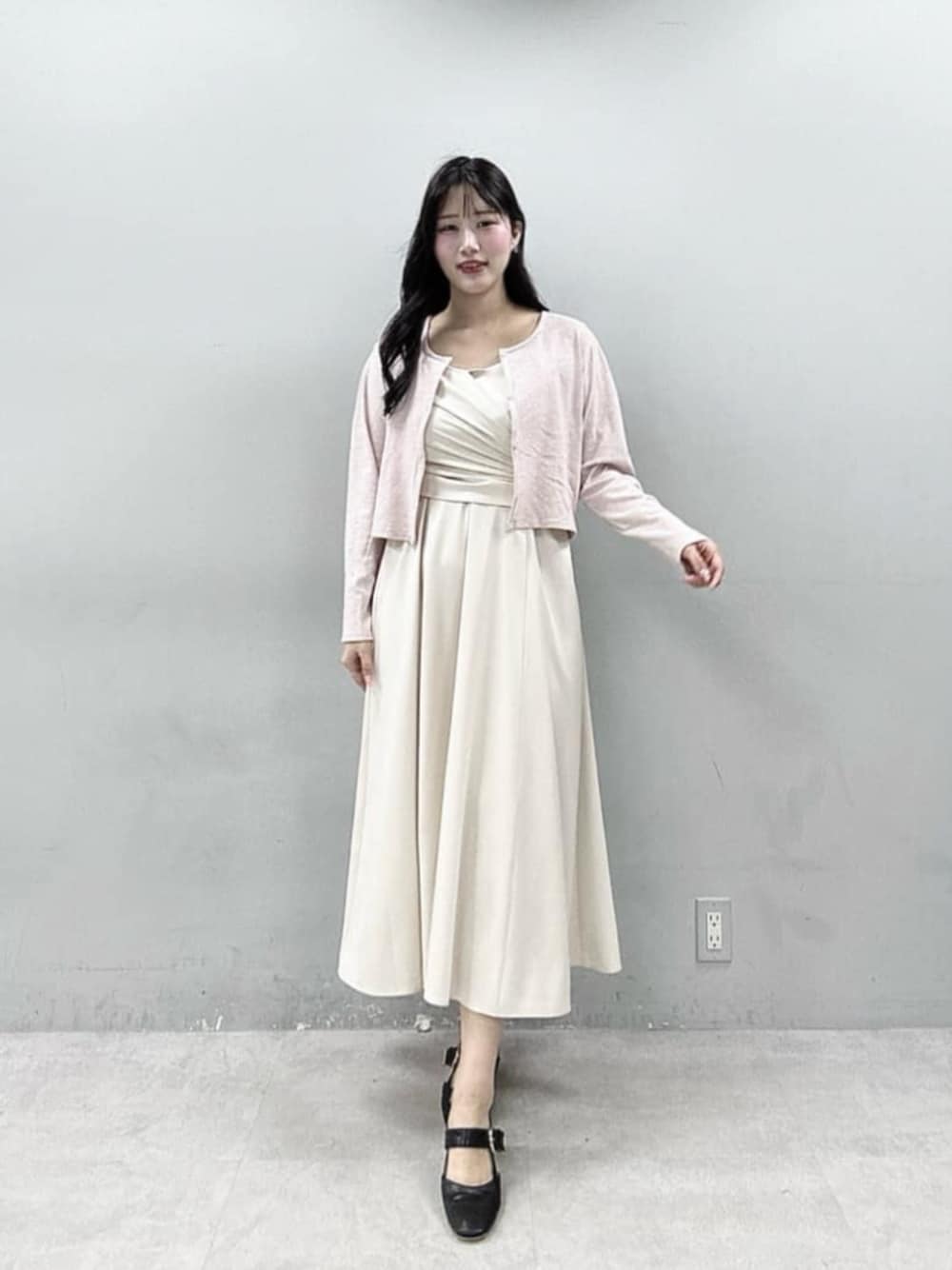 ピンク系のカーディガン/ボレロ、ホワイト系のワンピースを着用したレディースの春コーディネートの1枚目の写真