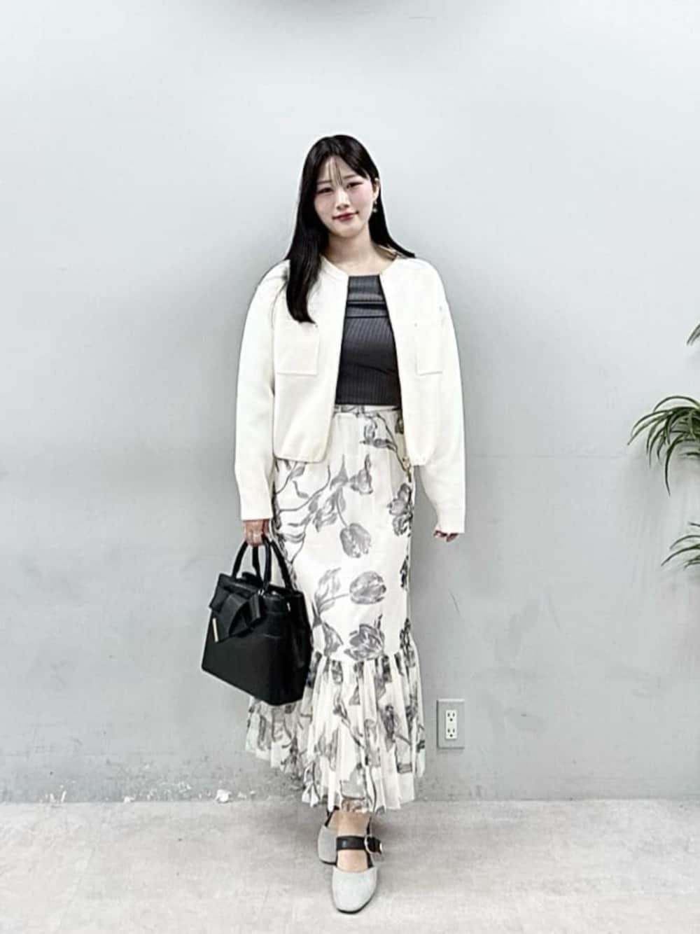 ブラック系のショルダーバッグ、ホワイト系のブルゾン、グレー系のニット/セーターを着用したレディースの春コーディネートの1枚目の写真