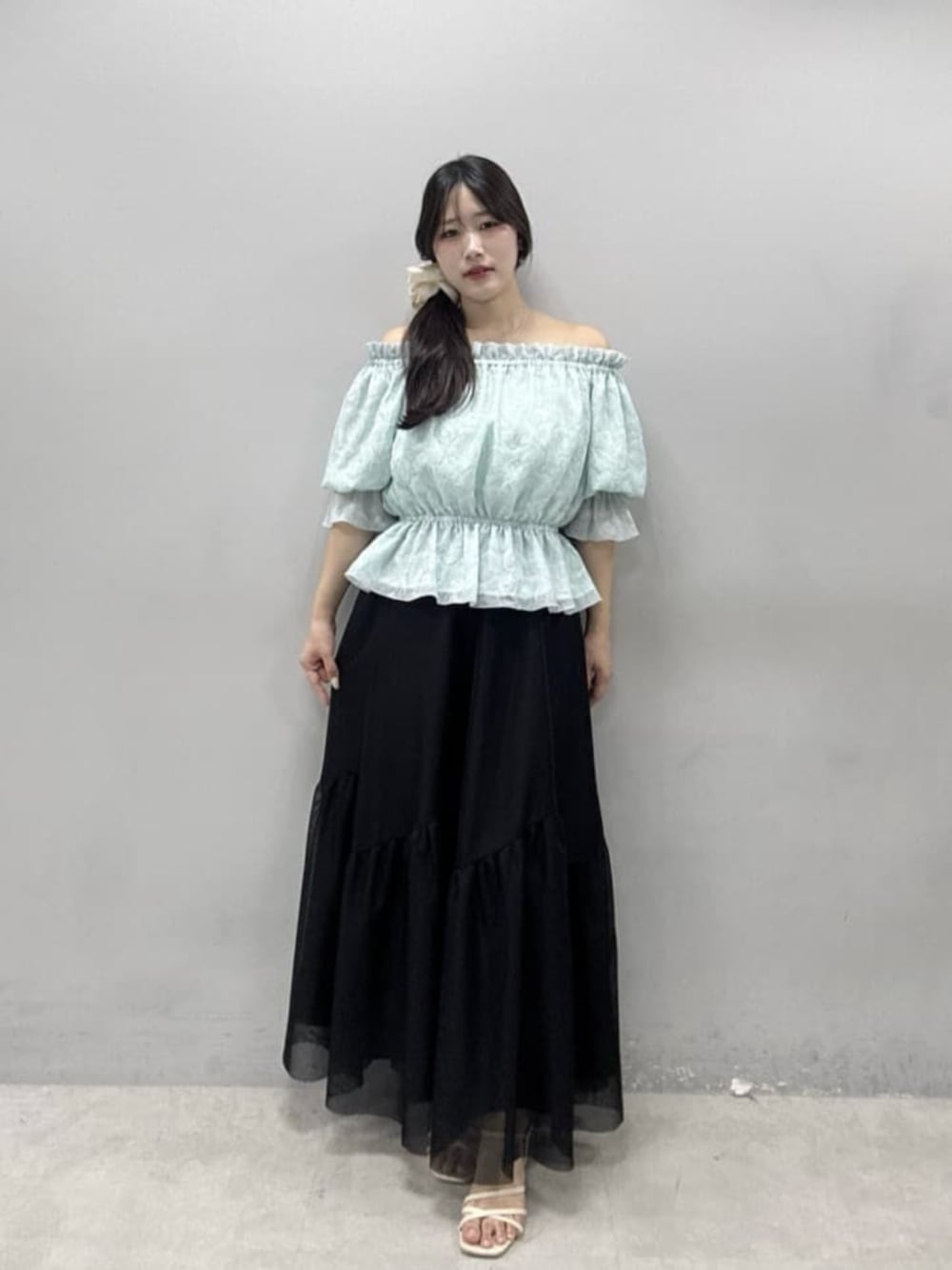 ブルー系のシャツ/ブラウス、ブラック系のスカートを着用したレディースの春コーディネートの1枚目の写真