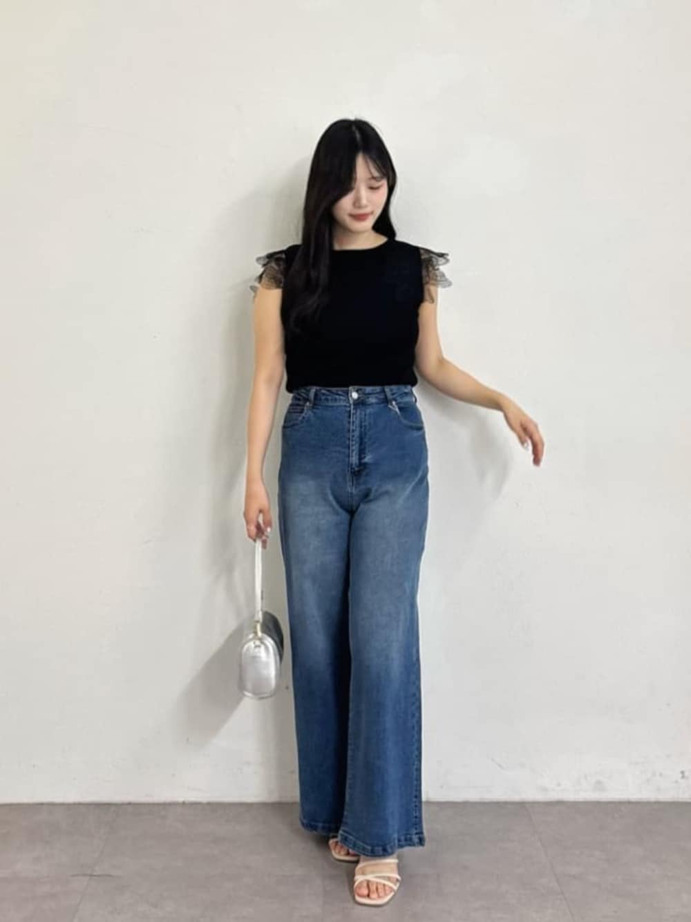 ブルー系のデニムパンツ、ブラック系のニット/セーターを着用したレディースの夏コーディネートの1枚目の写真