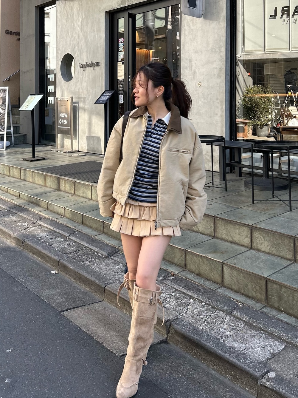 ベージュ系のブルゾン、ブルー系のTシャツ/カットソー、ベージュ系のスカートを着用したレディースの冬コーディネートの1枚目の写真