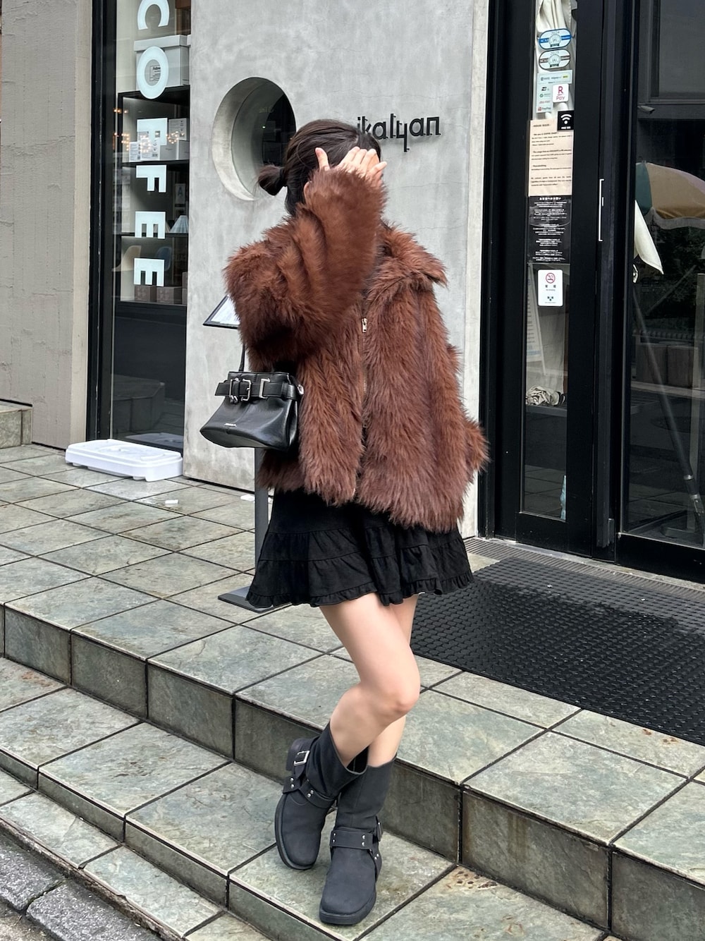 ブラック系のショルダーバッグ、ブラック系のブーツ、ブラック系のスカートを着用したレディースの秋コーディネートの1枚目の写真