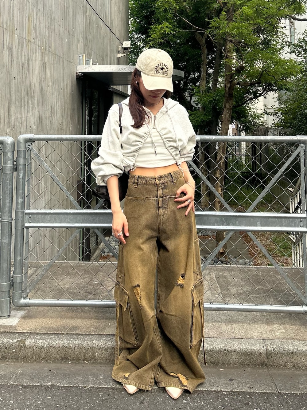 ホワイト系のカーディガン/ボレロ、ベージュ系のデニムパンツ、ホワイト系のキャップを着用したレディースの春コーディネートの1枚目の写真