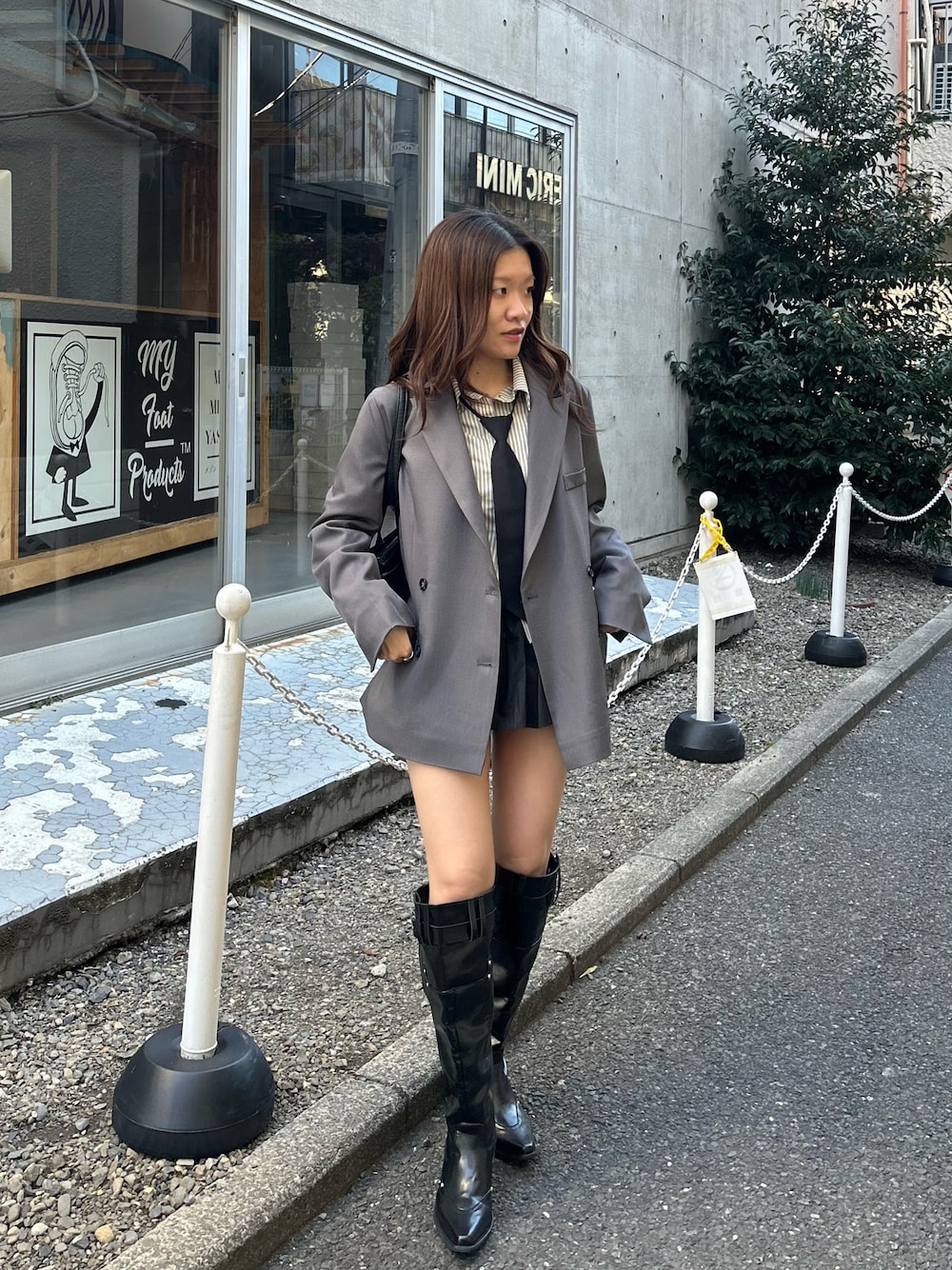 グレー系のテーラードジャケット、ブラック系のブーツを着用したレディースの冬コーディネートの1枚目の写真