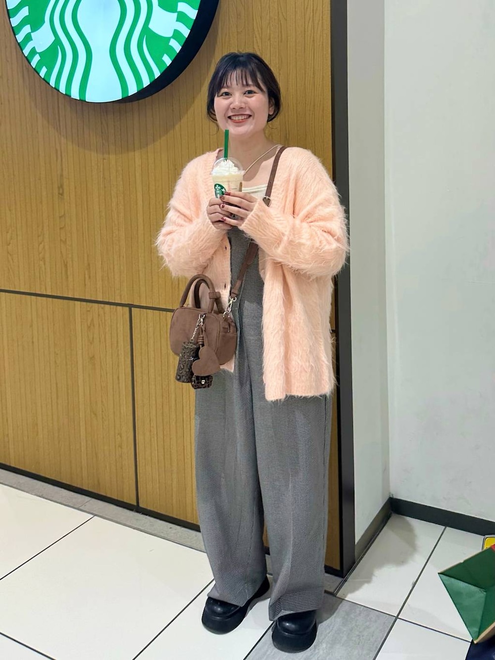 ブラック系のサンダル、ブラウン系のボストンバッグ、ピンク系のカーディガン/ボレロを着用したレディースの秋コーディネートの1枚目の写真