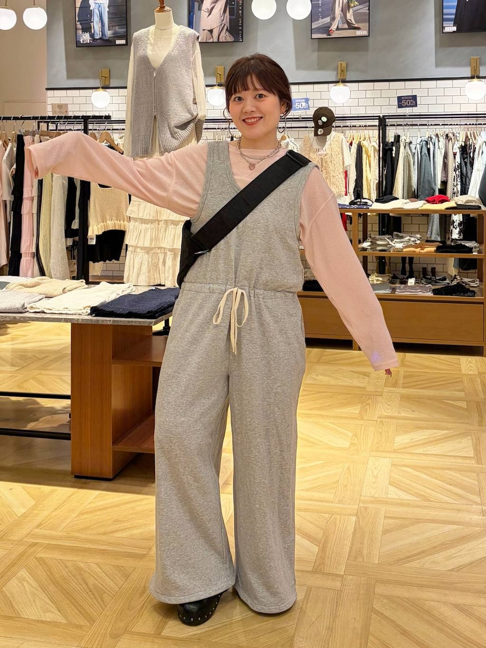 ピンク系のTシャツ/カットソー、ブラック系のサンダル、ブラック系のショルダーバッグを着用したレディースの春コーディネートの1枚目の写真