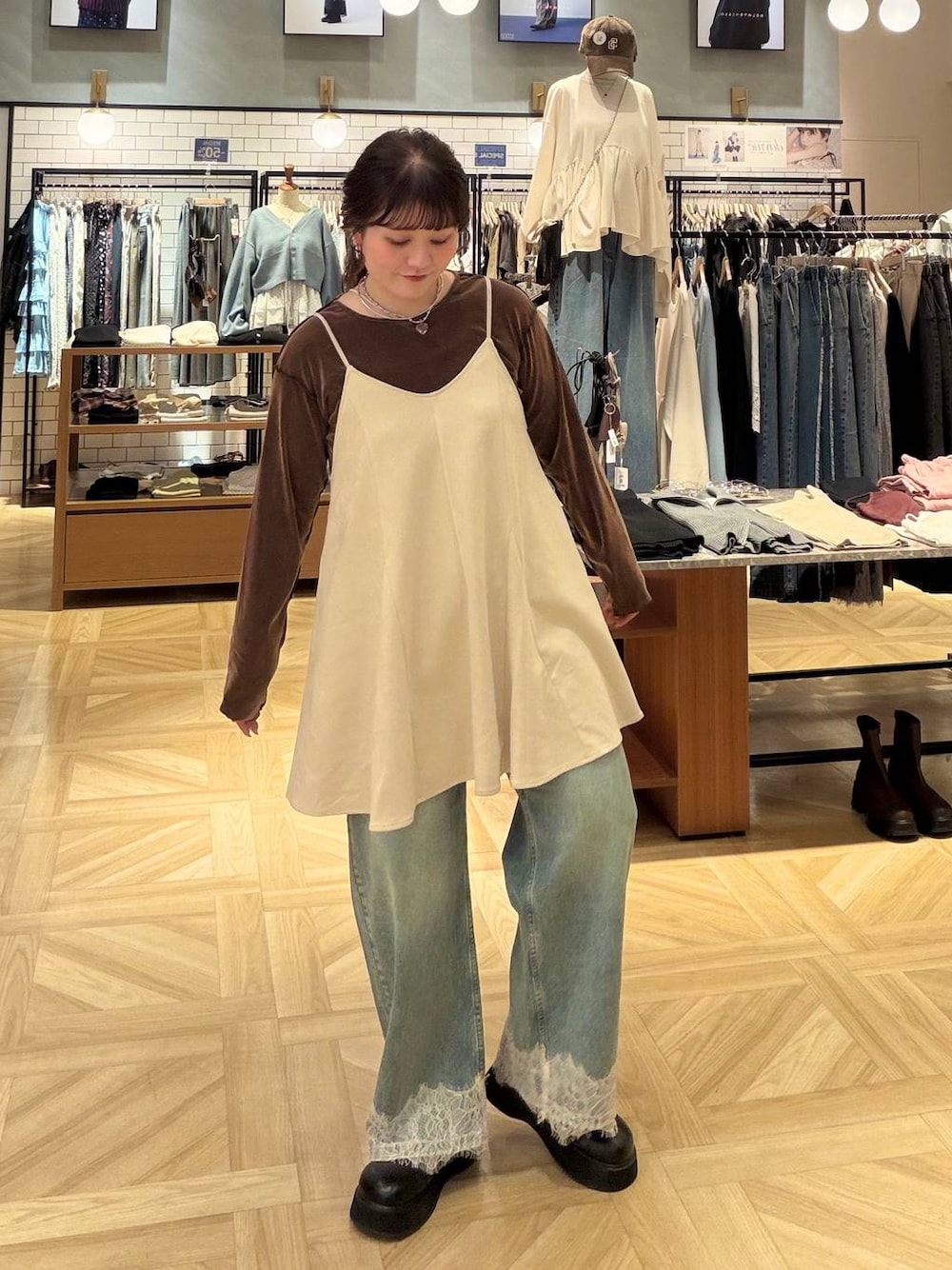 ホワイト系のスカート、ブラウン系のTシャツ/カットソー、ブルー系のデニムパンツを着用したレディースの秋コーディネートの1枚目の写真