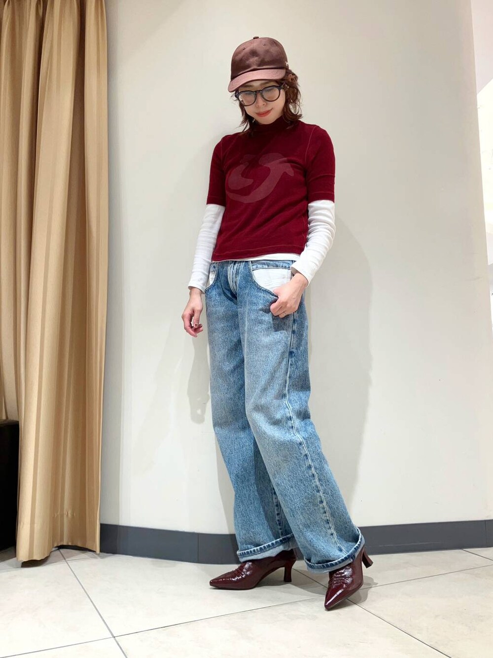 レッド系のパンプスを着用したレディースの秋コーディネートの1枚目の写真