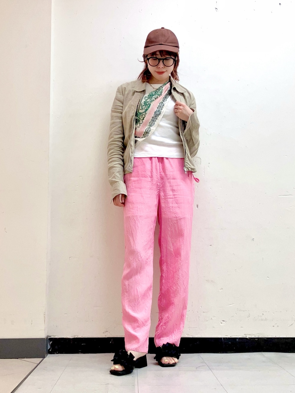 ブラック系のサンダル、ベージュ系のトップス、ホワイト系のTシャツ/カットソーを着用したレディースの春コーディネートの1枚目の写真