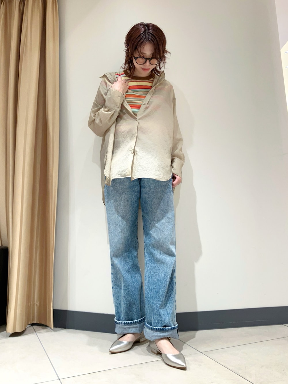 シルバー系のパンプス、ブルー系のデニムパンツ、ブラウン系のニット/セーターを着用したレディースの秋コーディネートの1枚目の写真