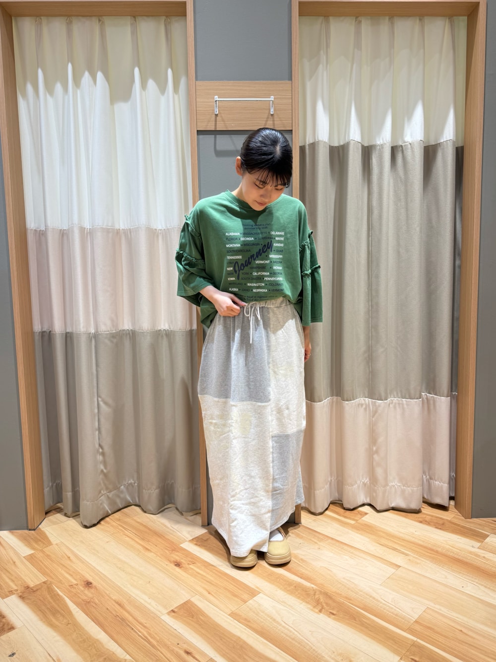 イエロー系のスニーカー、グレー系のスカート、グリーン系のTシャツ/カットソーを着用したレディースの春コーディネートの1枚目の写真