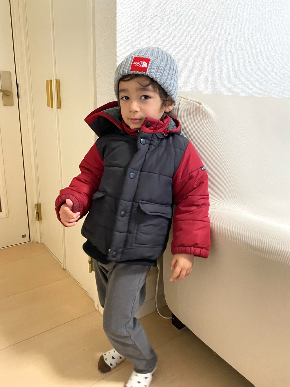 「公園コーデ、ニットキャップ、グレーコーデ、赤ポイント使い、あったかコーデ」｜「THE NORTH FACEのアイテム（ニットキャップ/ビーニー、グレー系）」を使った、DENNISさん（キッズ・100cm）の冬コーディネートの1枚目の写真