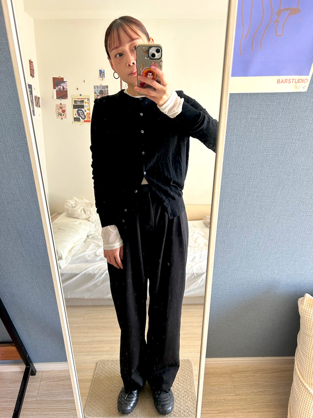 ブラック系のカーディガン/ボレロ、ブラック系のスラックス、ブラック系のスニーカーを着用したレディースの秋コーディネートの1枚目の写真