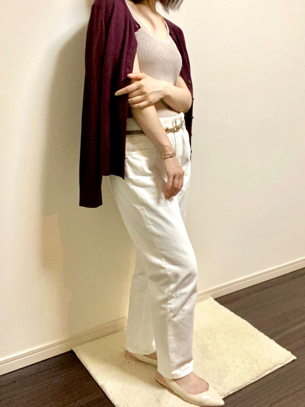 ホワイト系のデニムパンツ、ベージュ系のタンクトップ、パープル系のカーディガン/ボレロを着用したレディースの秋コーディネートの1枚目の写真