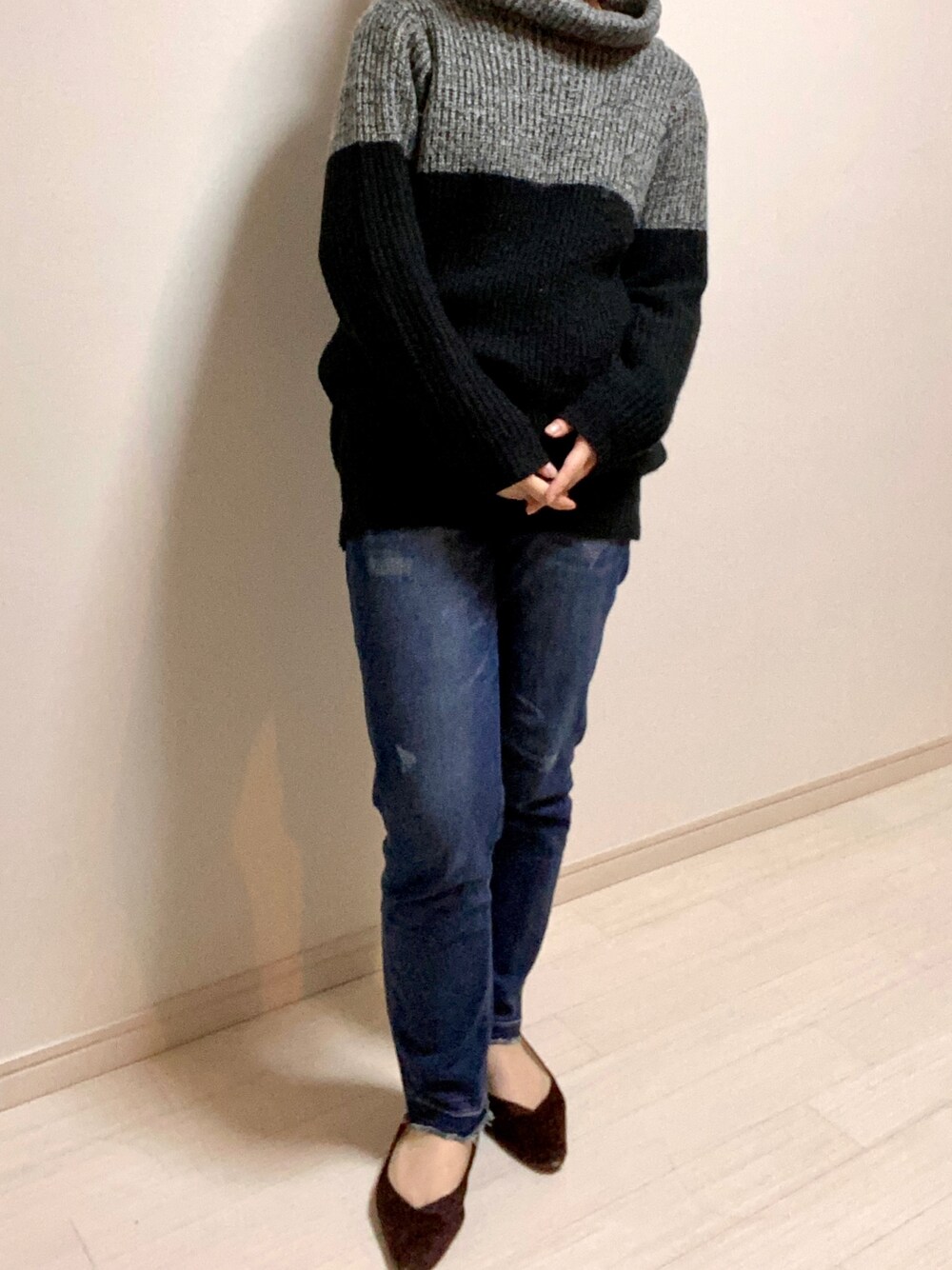 ブルー系のデニムパンツ、ブラウン系のパンプス、ブラック系のニット/セーターを着用したレディースの秋コーディネートの1枚目の写真