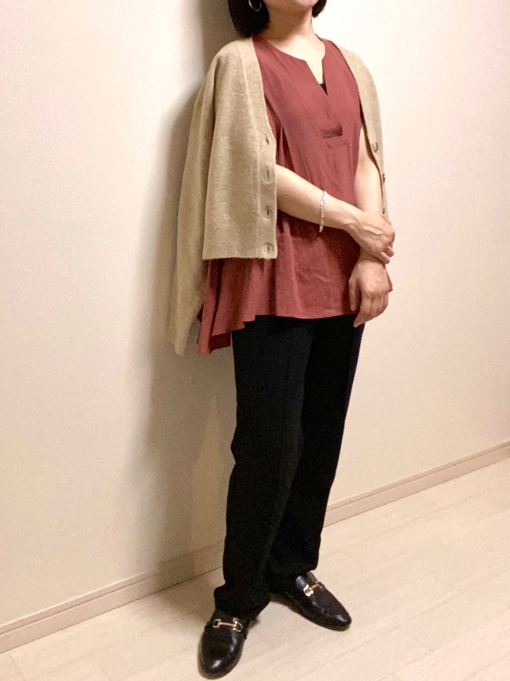 ブラック系のスウェットパンツ、ブラック系のローファー、ベージュ系のカーディガン/ボレロを着用したレディースの秋コーディネートの1枚目の写真