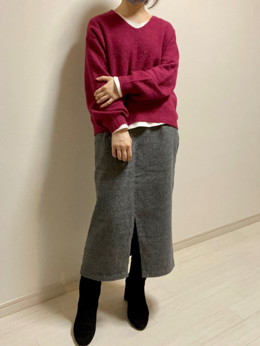 グレー系のスカート、ブラック系のブーツ、ピンク系のニット/セーターを着用したレディースの冬コーディネートの1枚目の写真