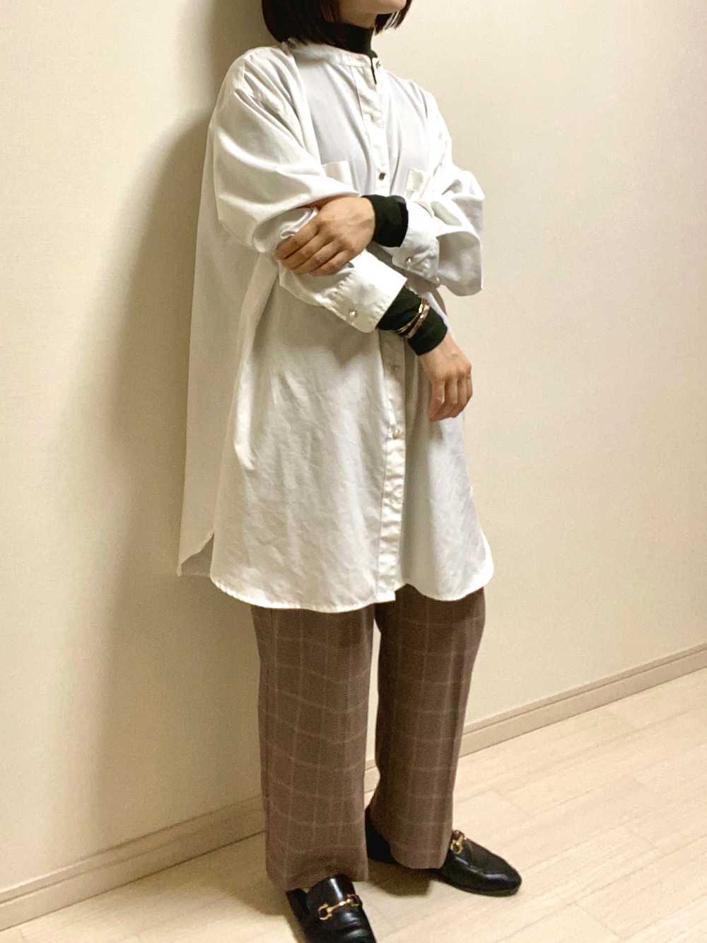 ブラウン系のスラックス、ブラック系のローファー、ホワイト系のシャツ/ブラウスを着用したレディースの秋コーディネートの1枚目の写真